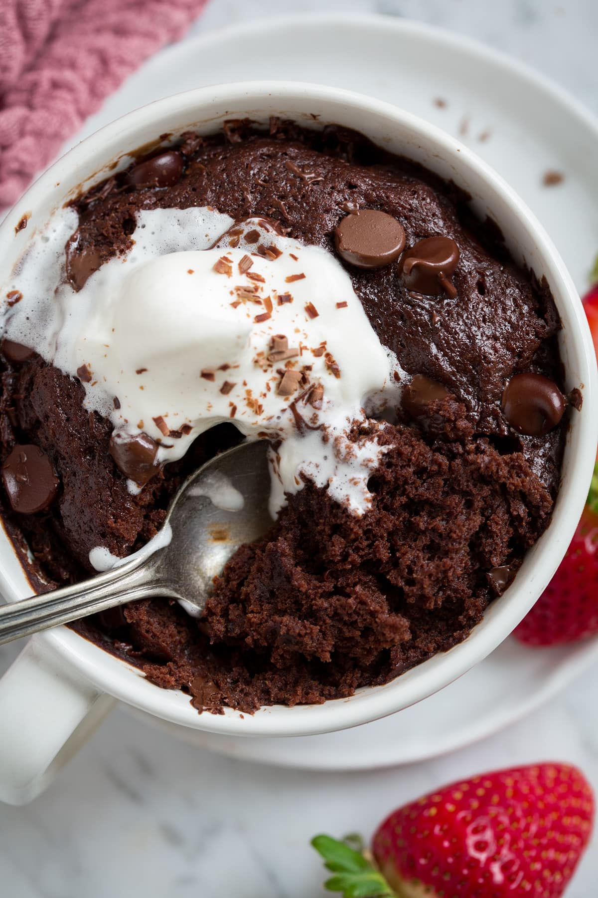 Close up image of chocolate mug cake being scooped into with a spoon.