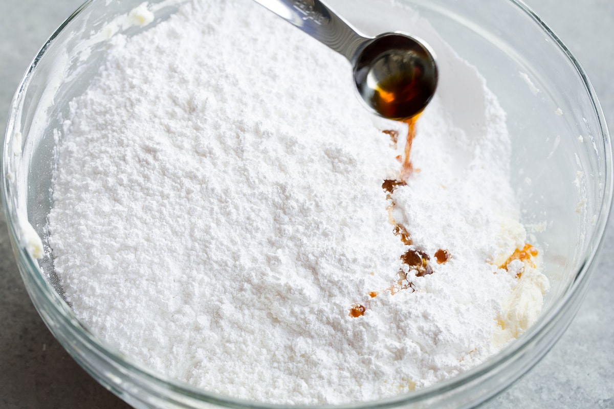 Powdered sugar and vanilla added to mixing bowl with butter and cream cheese.