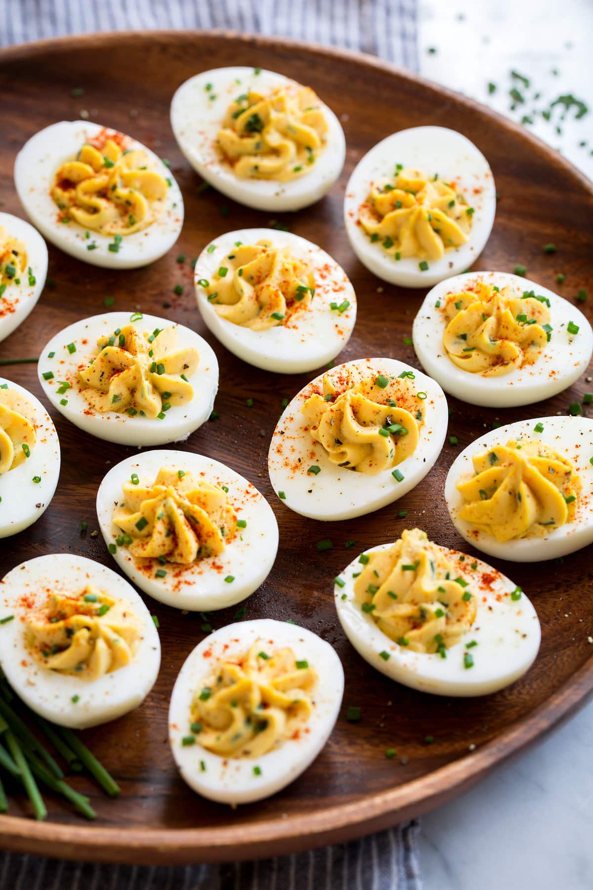 Plain deviled eggs on a wooden platter (no bacon).