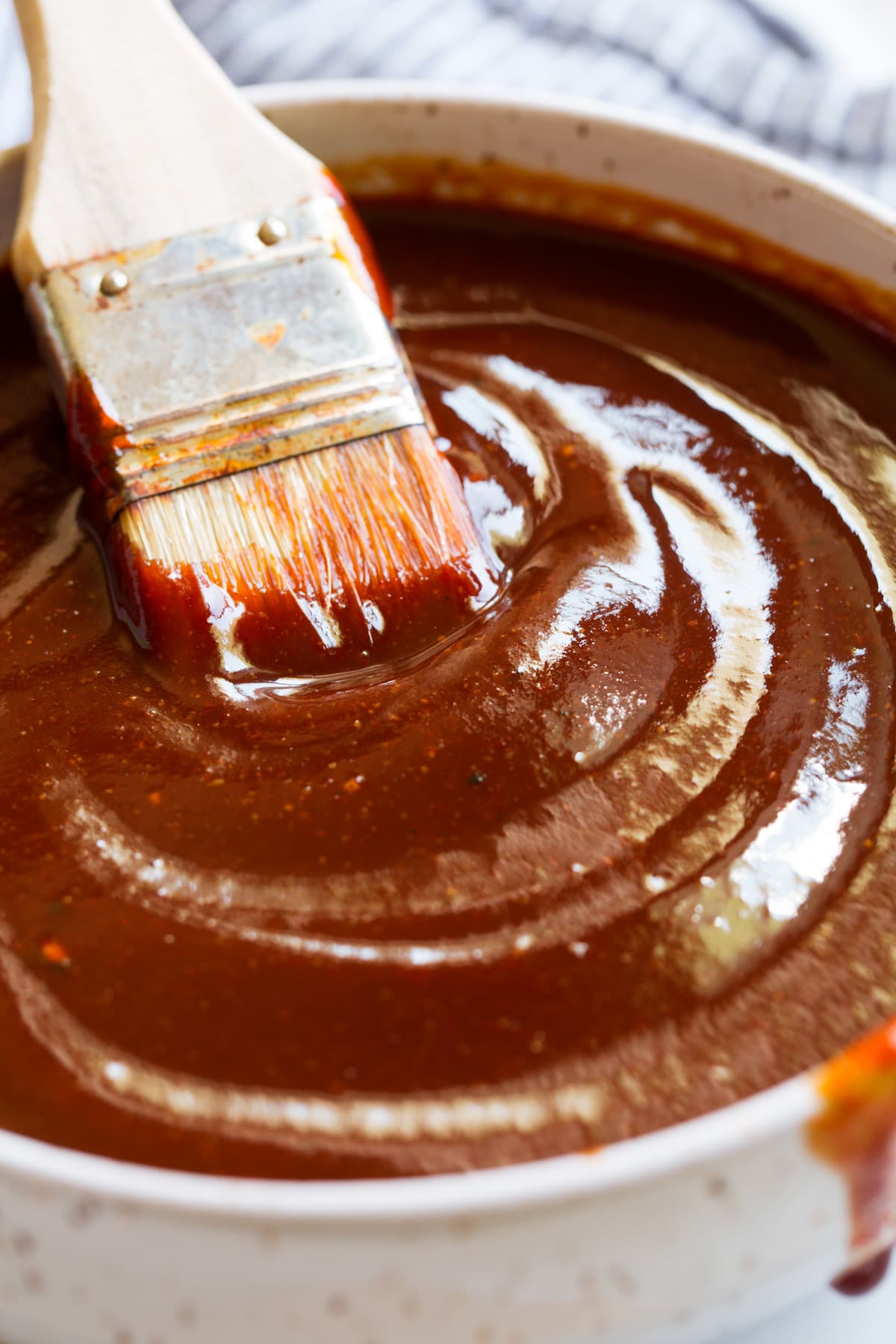 Close up image of bbq sauce with basting brush in a bowl.