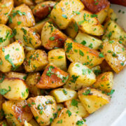 Lemon roasted potatoes in a white serving bowl.