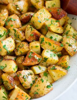 Lemon roasted potatoes in a white serving bowl.
