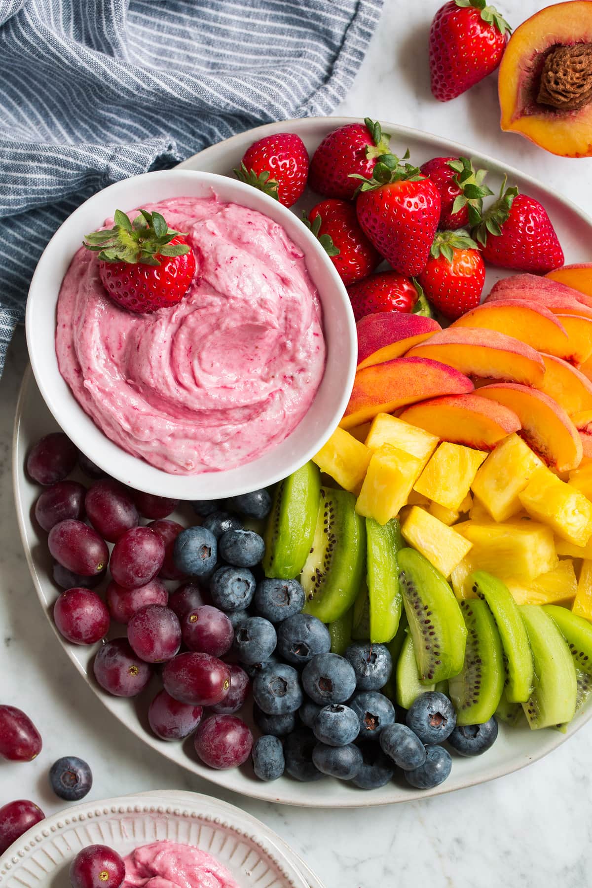 Overhead image of easy cream cheese fruit dip on a platter with fresh fruit on the side.
