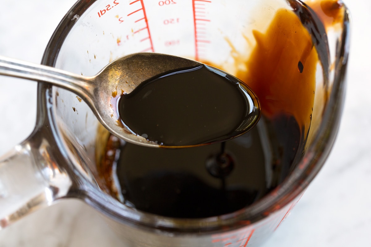 Balsamic glaze shown in a spoon after reduced and thickened.