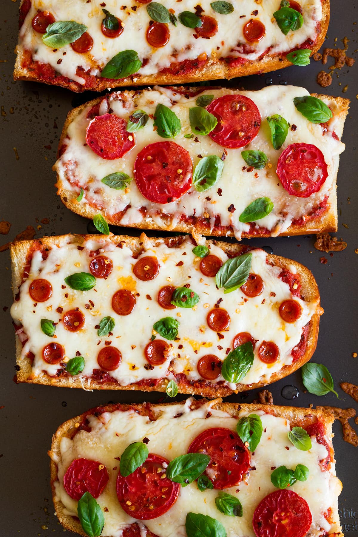Close up image of four big slices of french bread pizza.