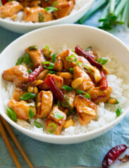 White bowl filled with rice and kung pao chicken.