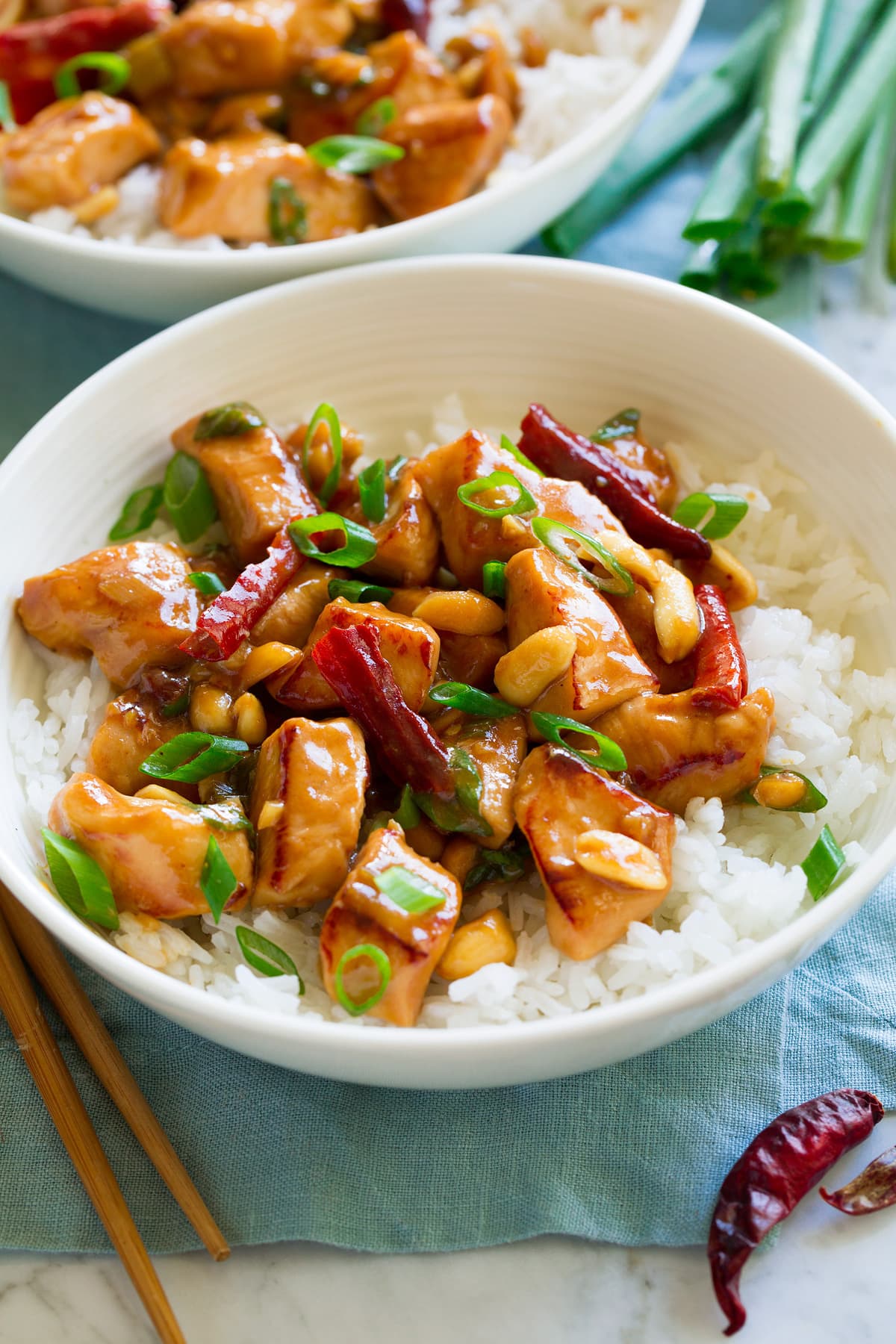 White bowl filled with rice and kung pao chicken.