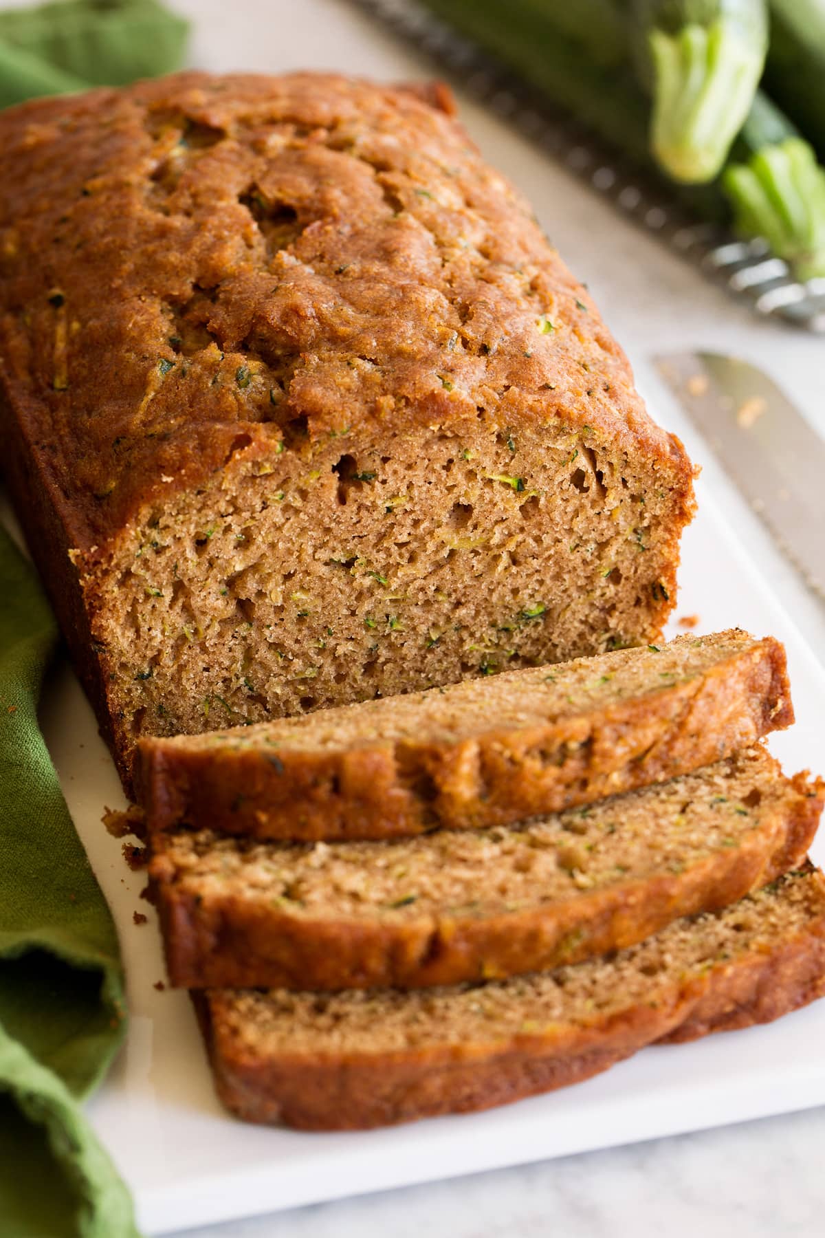 Loaf of zucchini bread shown with a few slices cut.