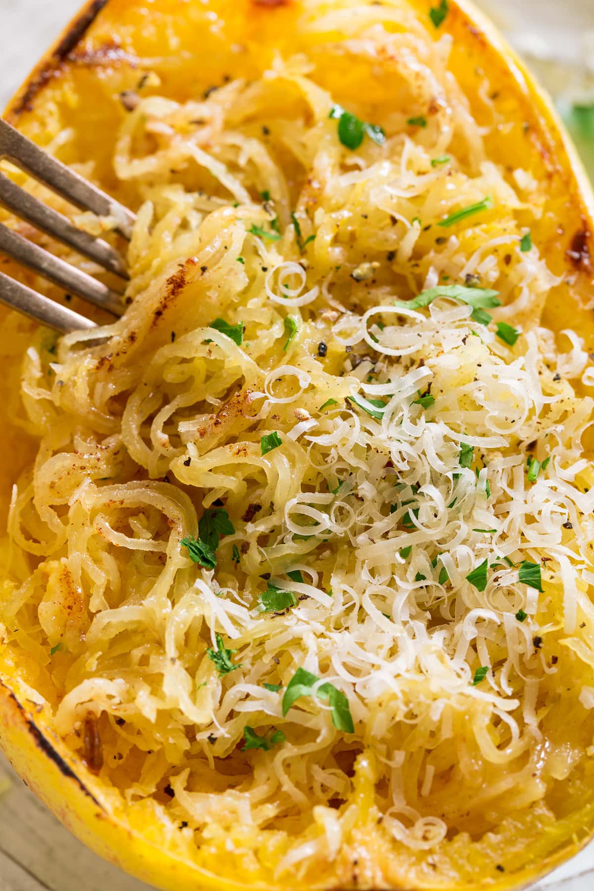 Close up image of roasted spaghetti squash shredded into strings, topped with browned butter and parmesan.