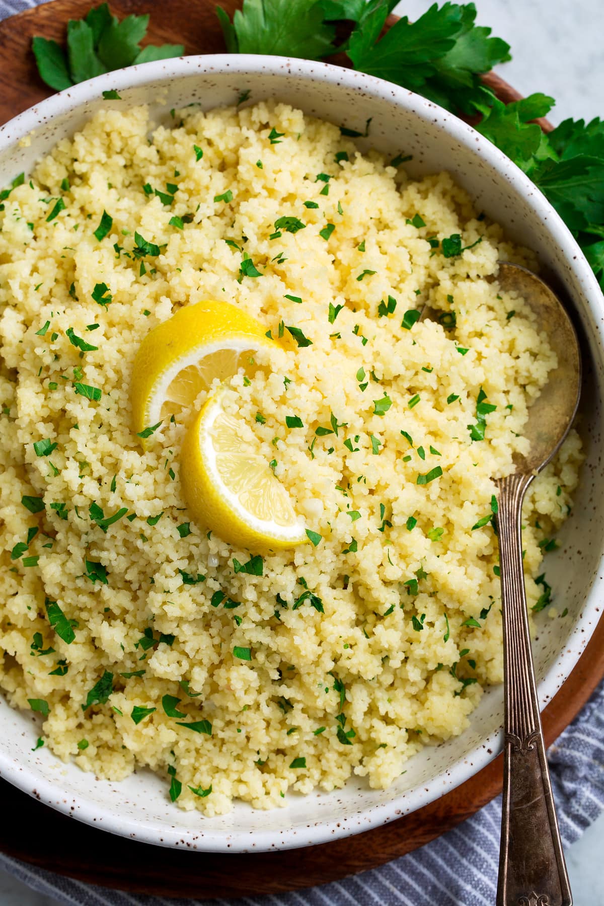 Close up overhead photo of lemon couscous garnished with parsley and lemon slices.