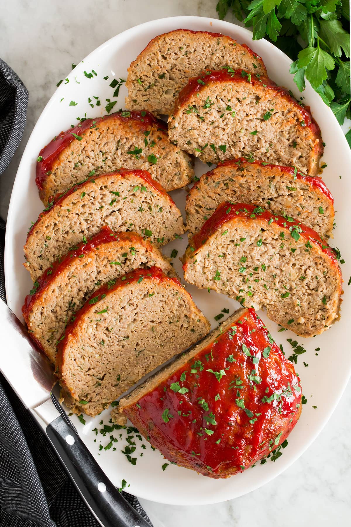 Photo showing slices of turkey meatloaf shown overhead on a white platter.