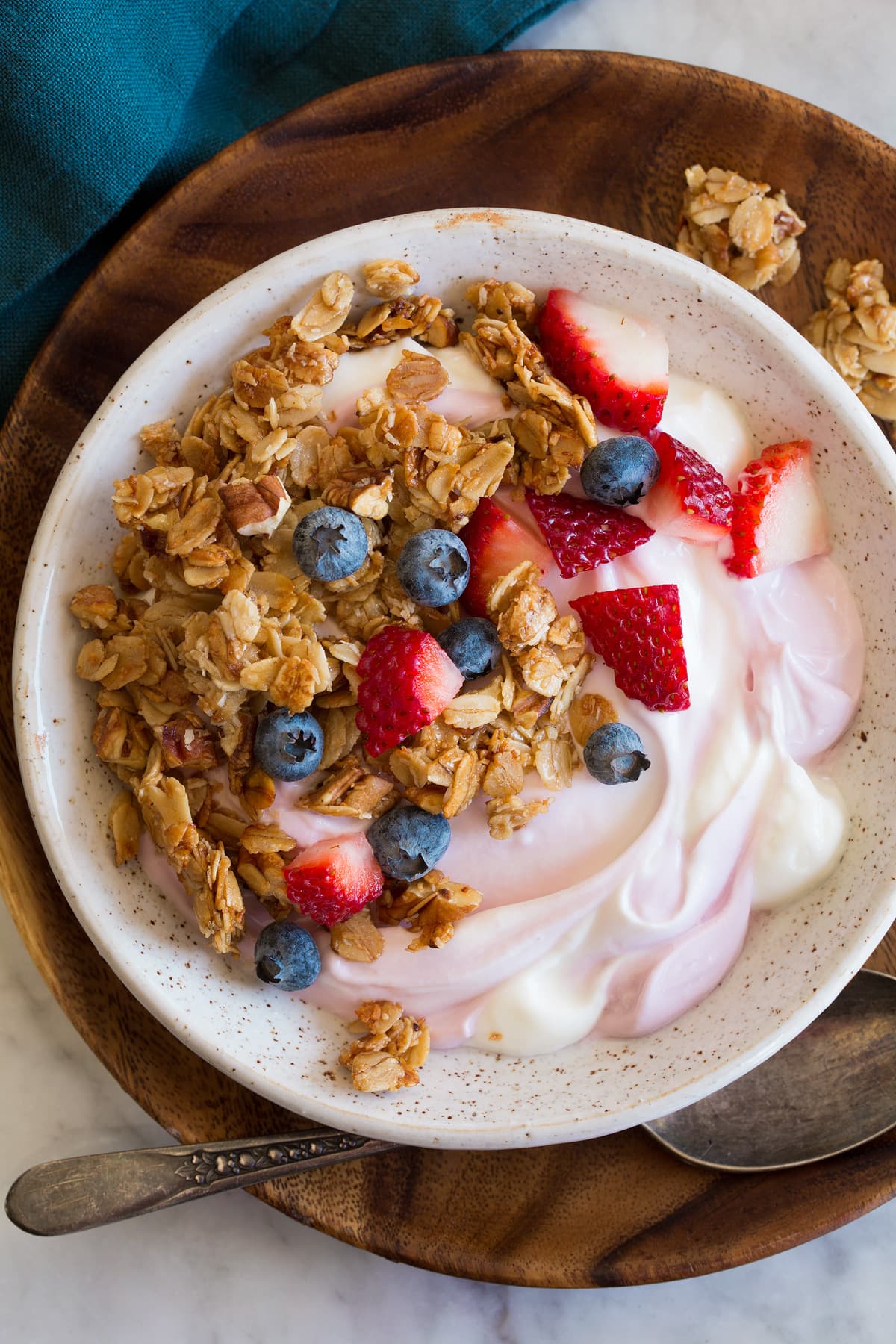 Granola, yogurt and fruit bowl shown from above.