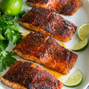 Photo: Blackened salmon shown topped with buttery honey lime sauce. Parsley and limes are shown as garnishes.