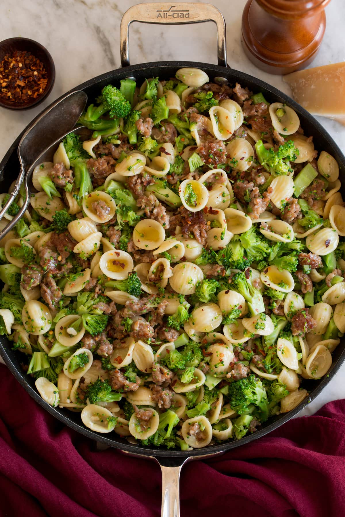 Photo: Orecchiette with sausage and broccoli shown in a black skillet from above.