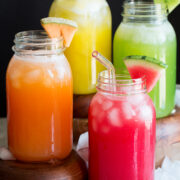 Photo: Four types of aqua fresca including watermelon, cantaloupe, honeydew and pineapple shown in glass mason jars.