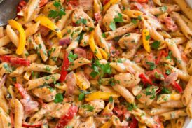 Photo: Creamy cajun chicken pasta shown in a large white pan from overhead.