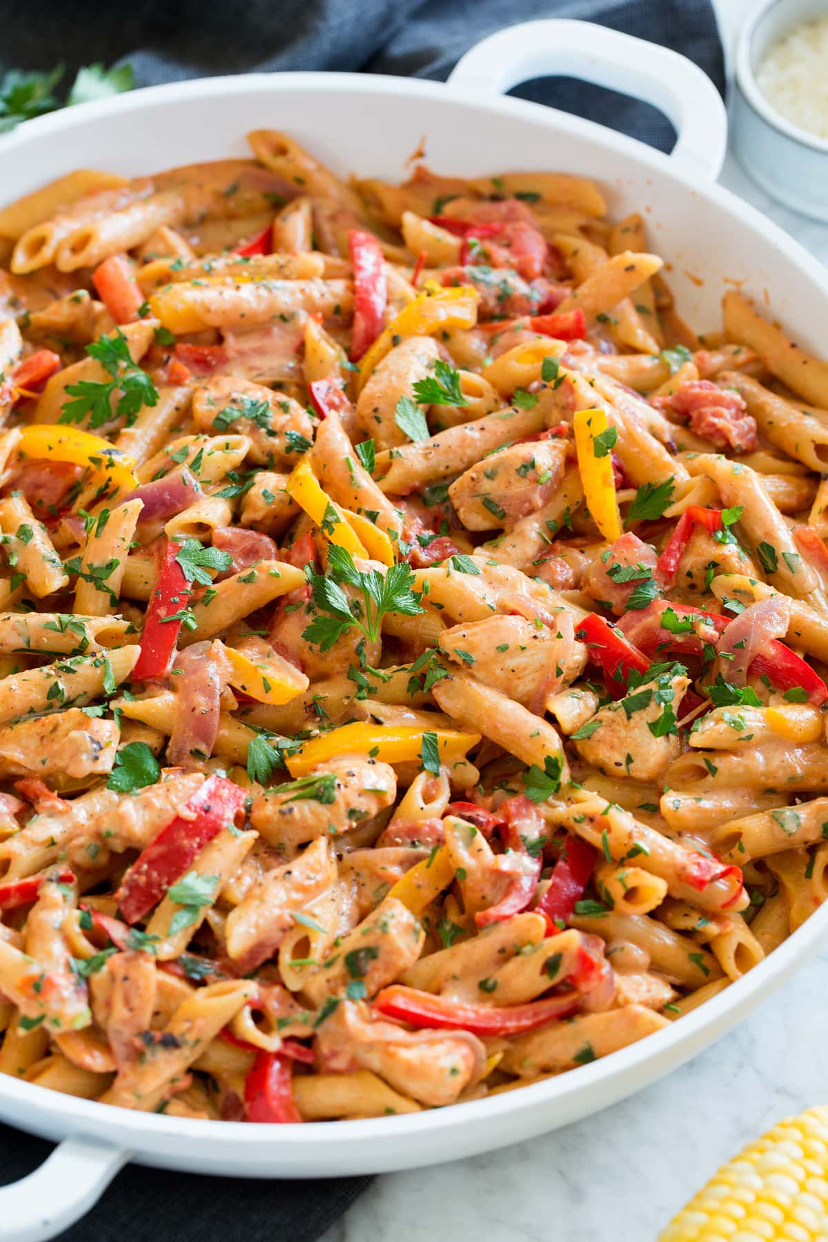 Photo: One pot cajun chicken pasta shown close up in a white pan from the side.