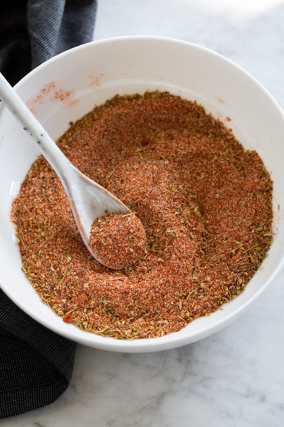 Photo: Mixed cajun seasoning in a small bowl with a spoon.