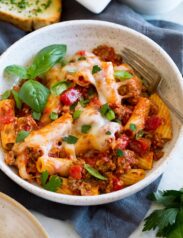 Rigatoni pasta with marinara sauce, beef and cheeses shown served in a pasta bowl.