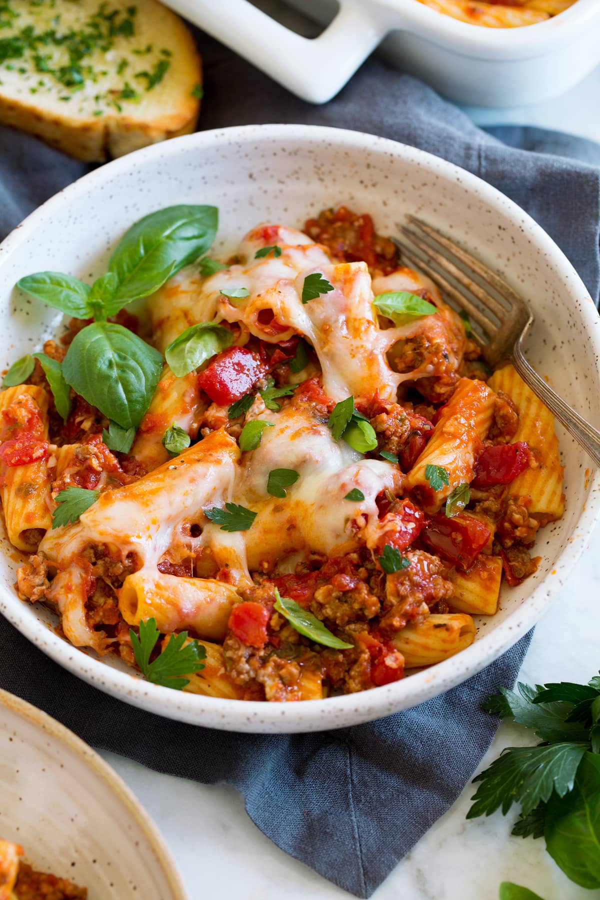 Rigatoni pasta with marinara sauce, beef and cheeses shown served in a pasta bowl.