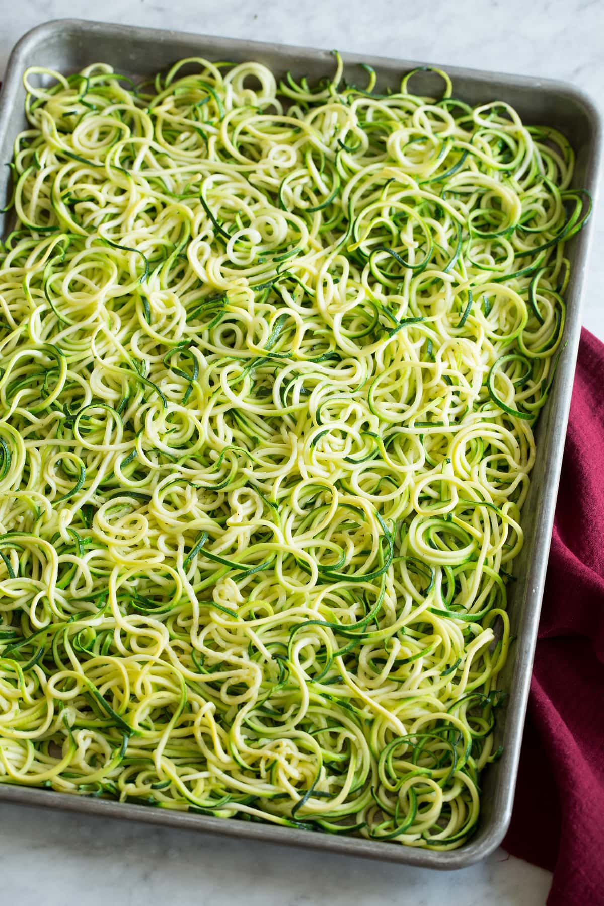 Roasted zoodles shown on a baking sheet from a side angle.