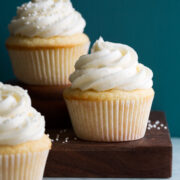 Photo of three vanilla cupcakes with vanilla buttercream frosting.