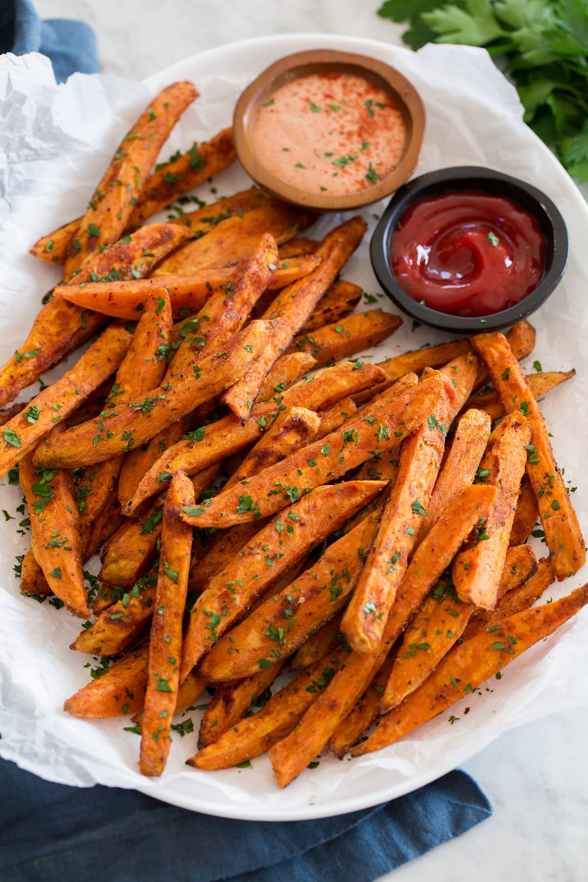 Side angle of baked sweet potato fries on a serving tray.