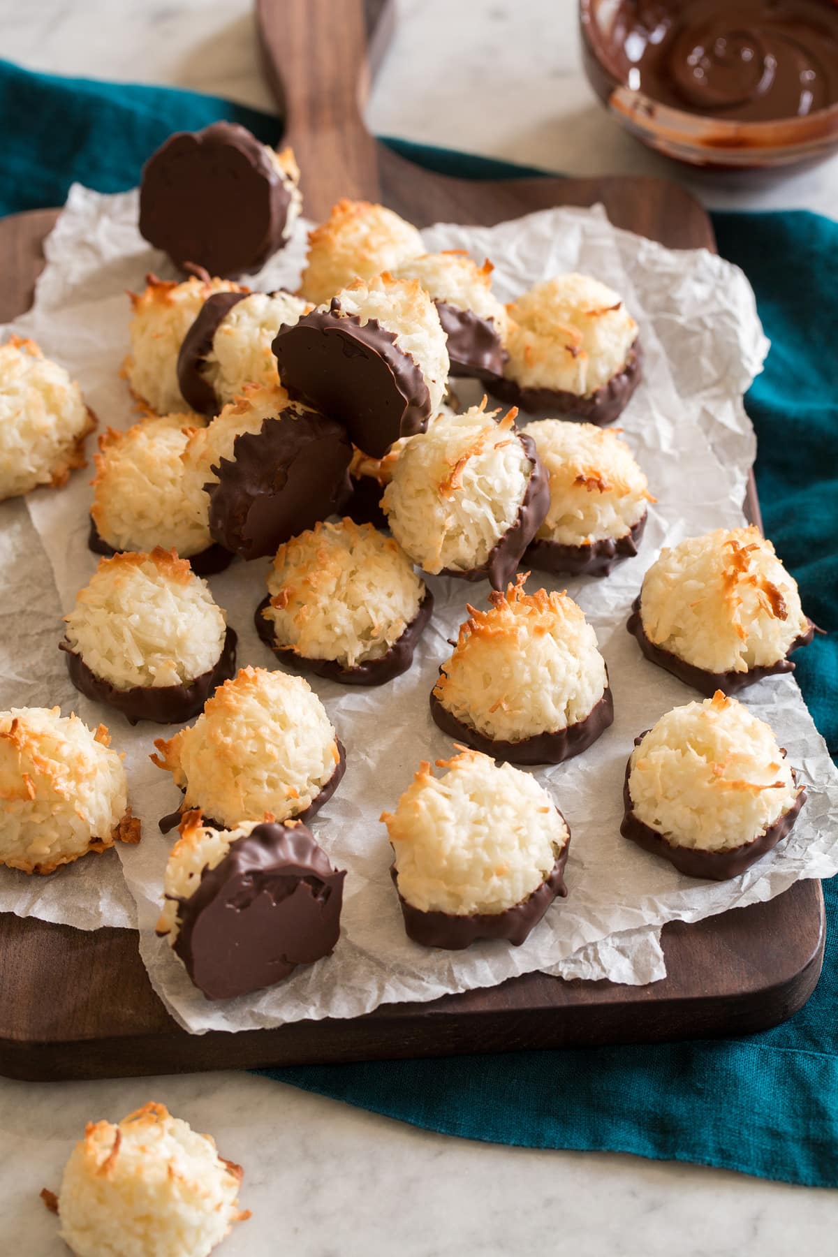 Coconut macaroons on parchment paper and a wooden board.