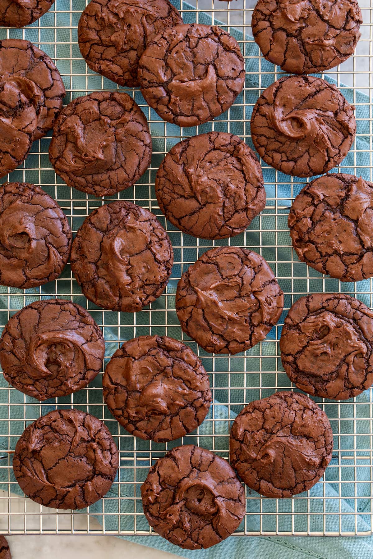 Overheat photo of chocolate brownie cookies on a silver wire cooling rack.
