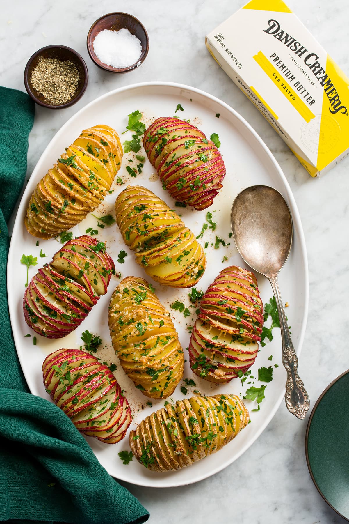 Overhead photo of hasselback potatoes on a white oval platter.