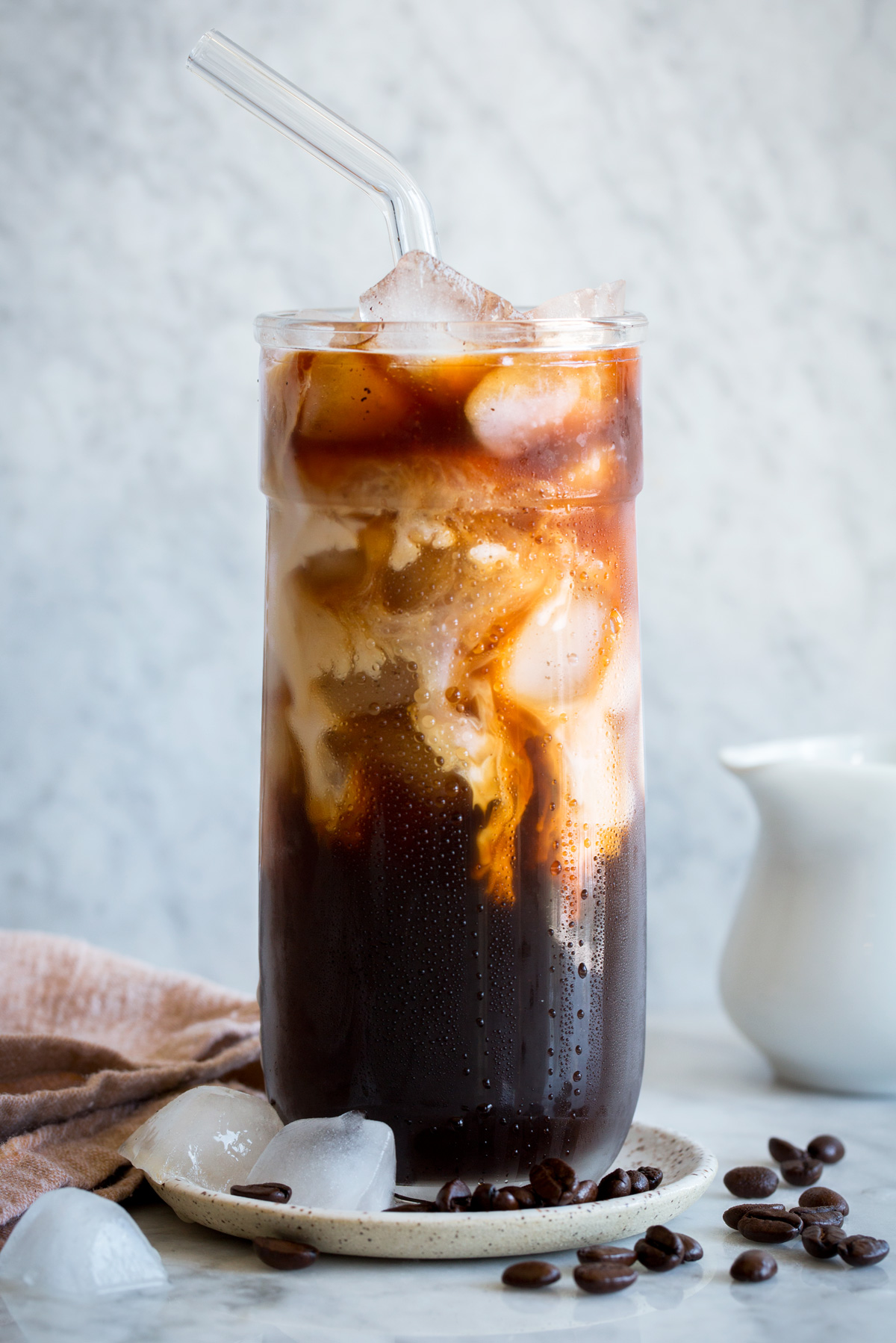 Tall glass of iced coffee with cream.