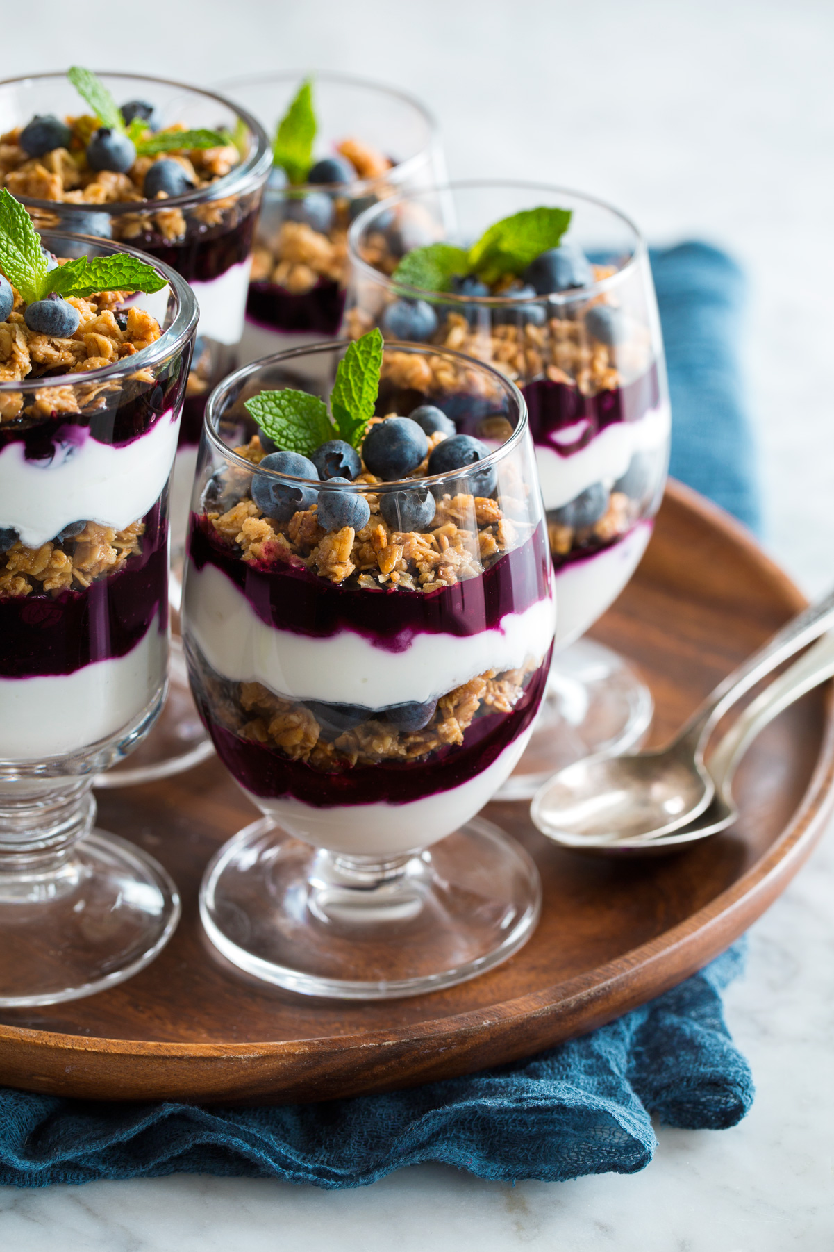 Yogurt Parfaits layered with plain Greek yogurt, blueberry sauce and granola.
