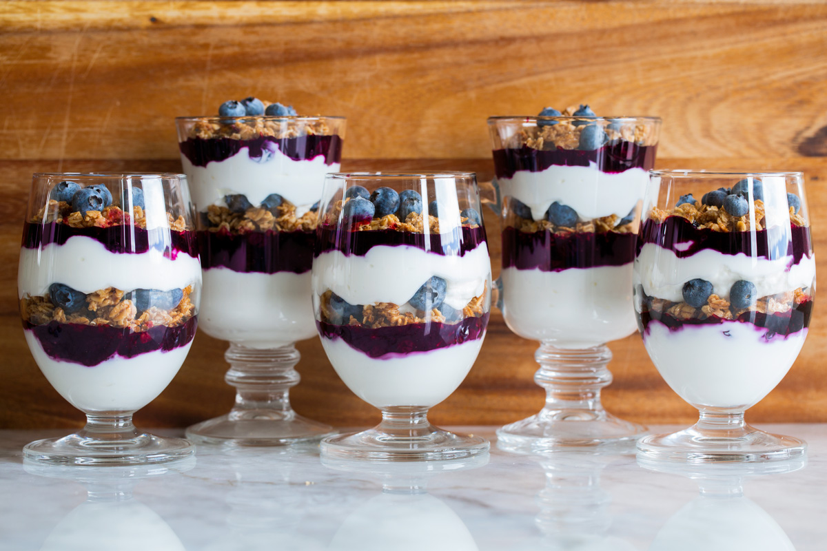 Five glasses filled with yogurt parfaits.