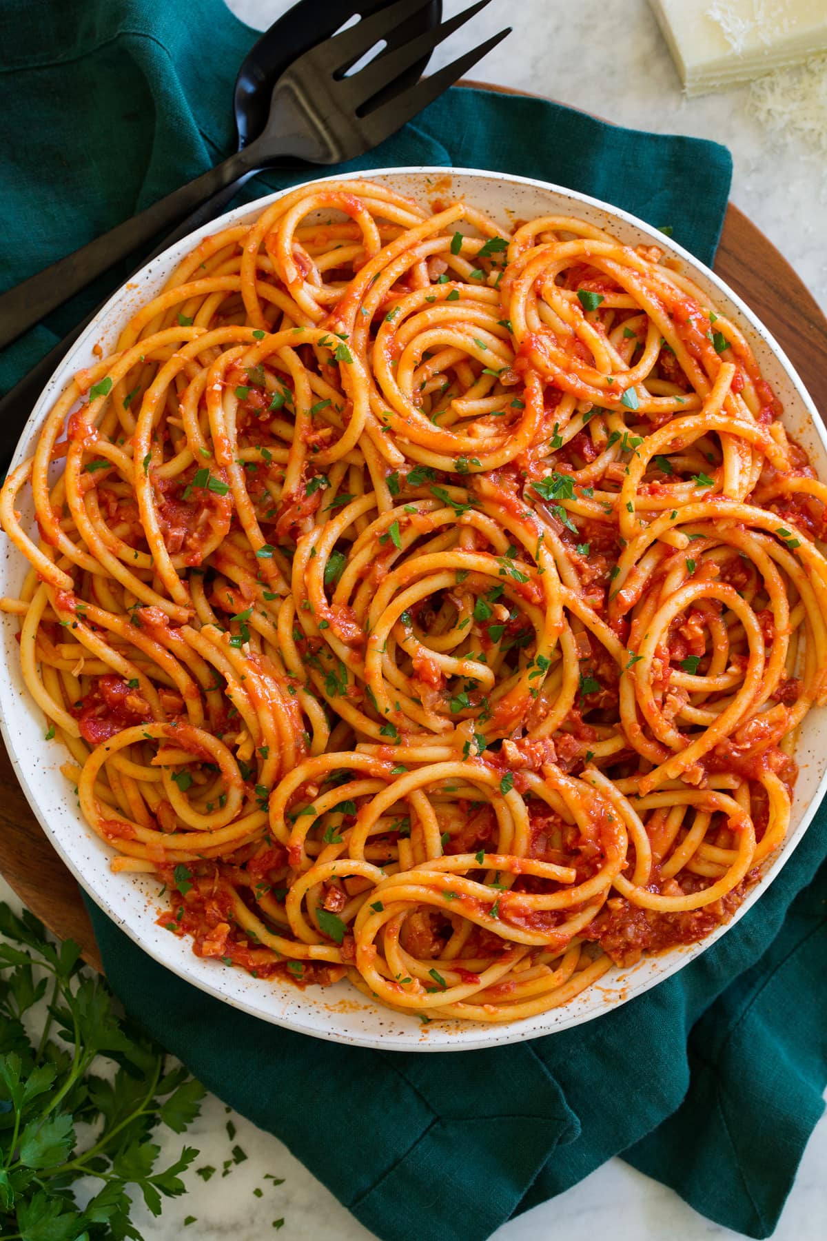 Overhead photo of cooked bucatini pasta with tomato sauce.