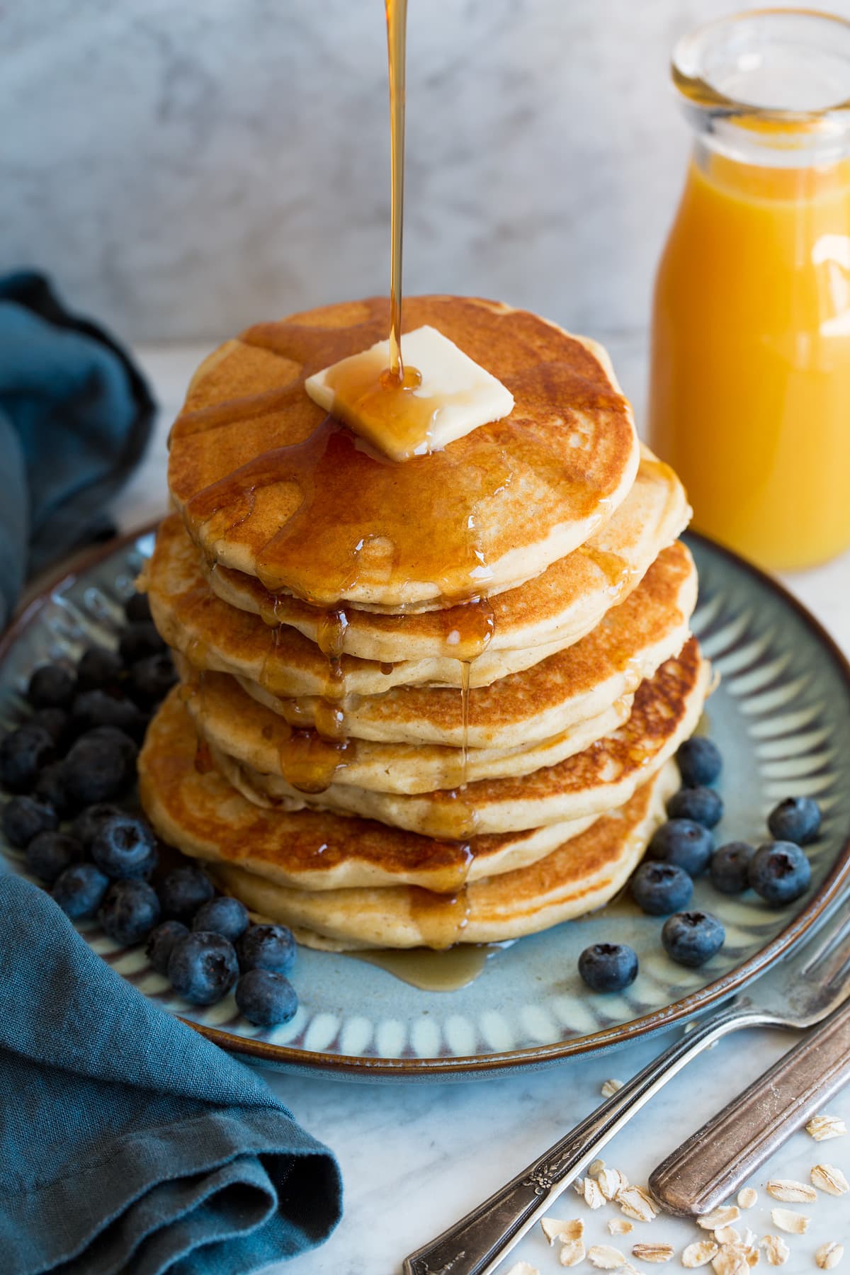 Stack of oat flour pancakes with syrup being poured over.