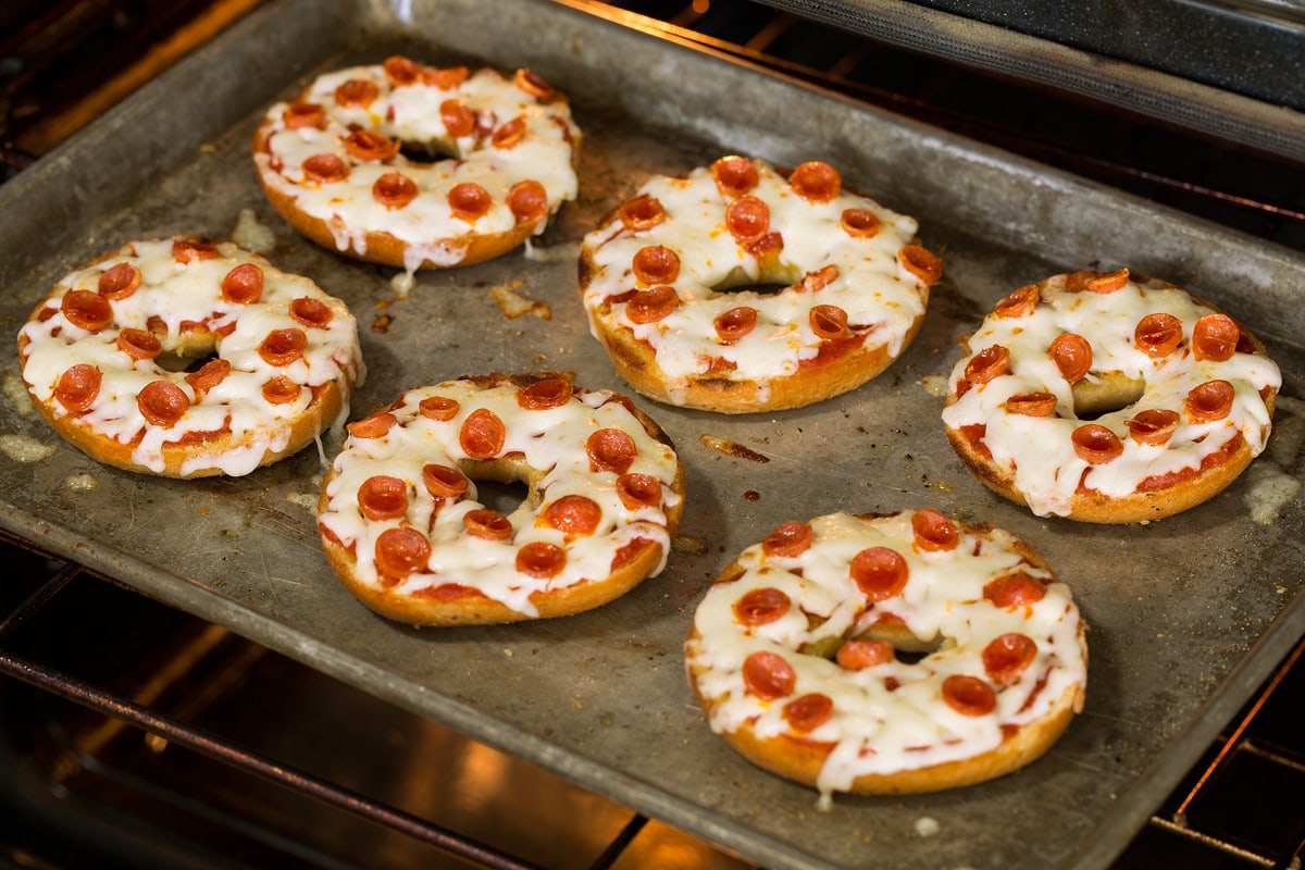 Pizza bagels toasting in the oven.