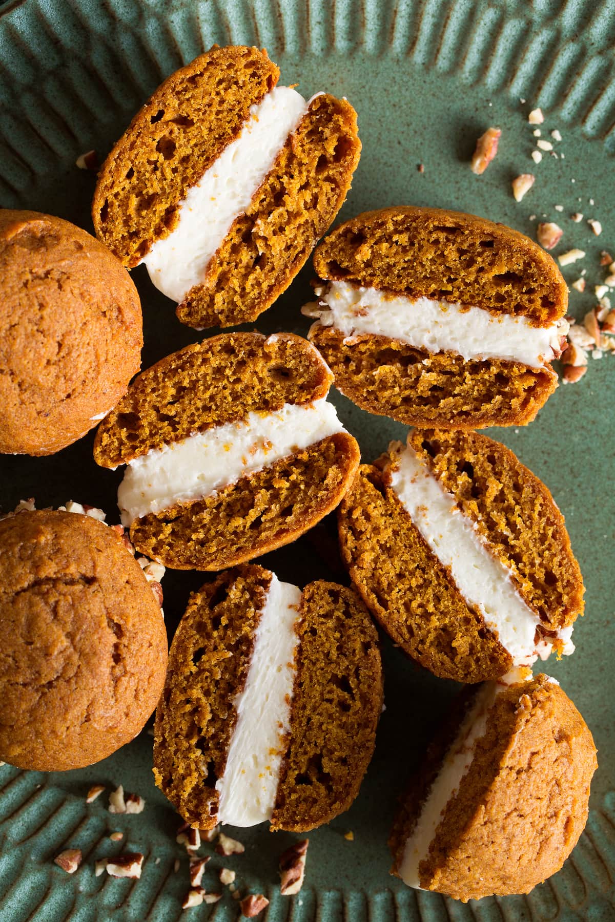 Pumpkin whoopie pies cut in half to show texture and frosting filling.