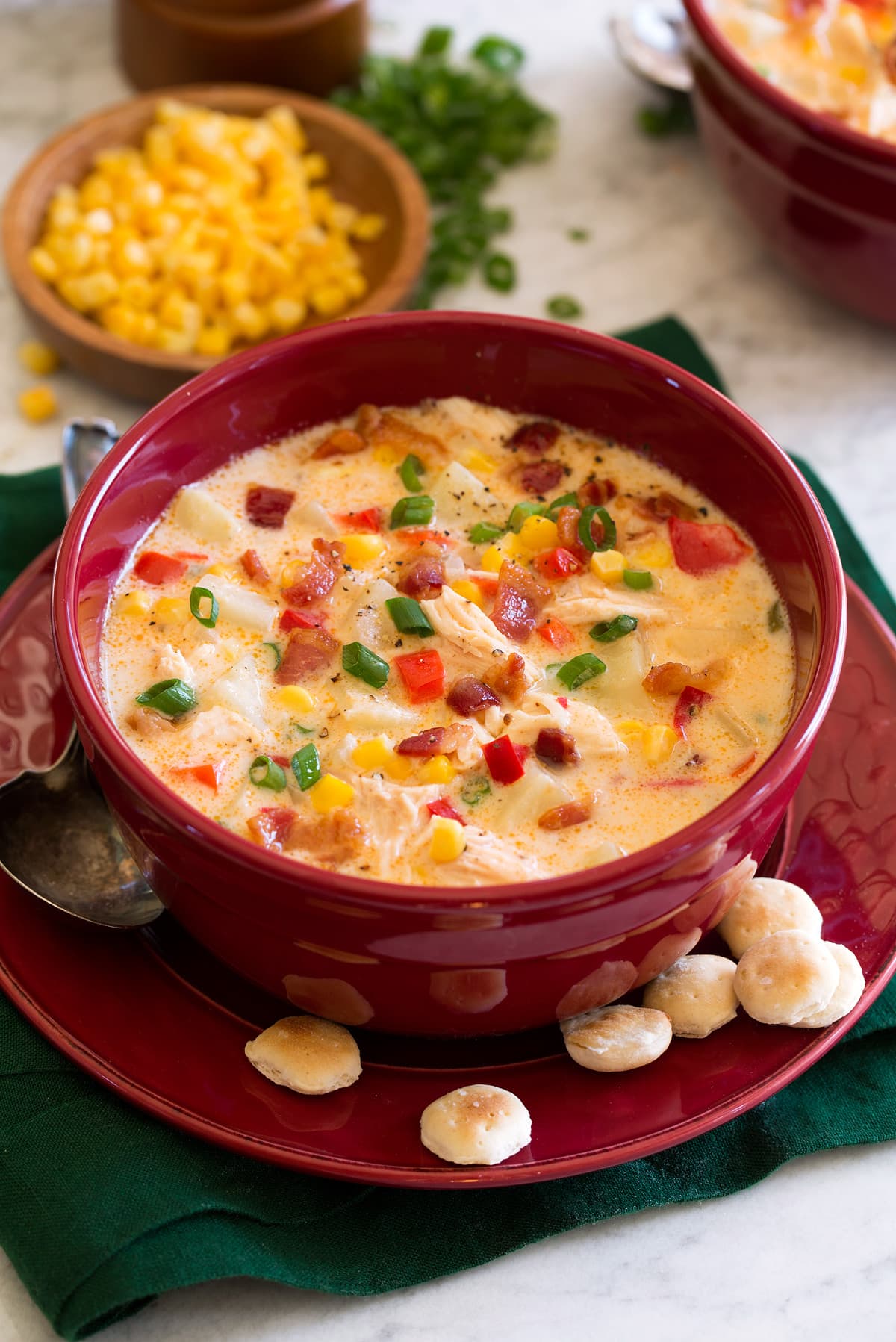 Chicken corn chowder in a serving bowl with oyster crackers to the side.