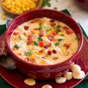 Chicken corn chowder in a serving bowl with oyster crackers to the side.