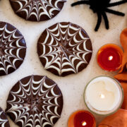 Primo piano foto che mostra le tubazioni di ragnatela di cioccolato sui biscotti di Halloween.