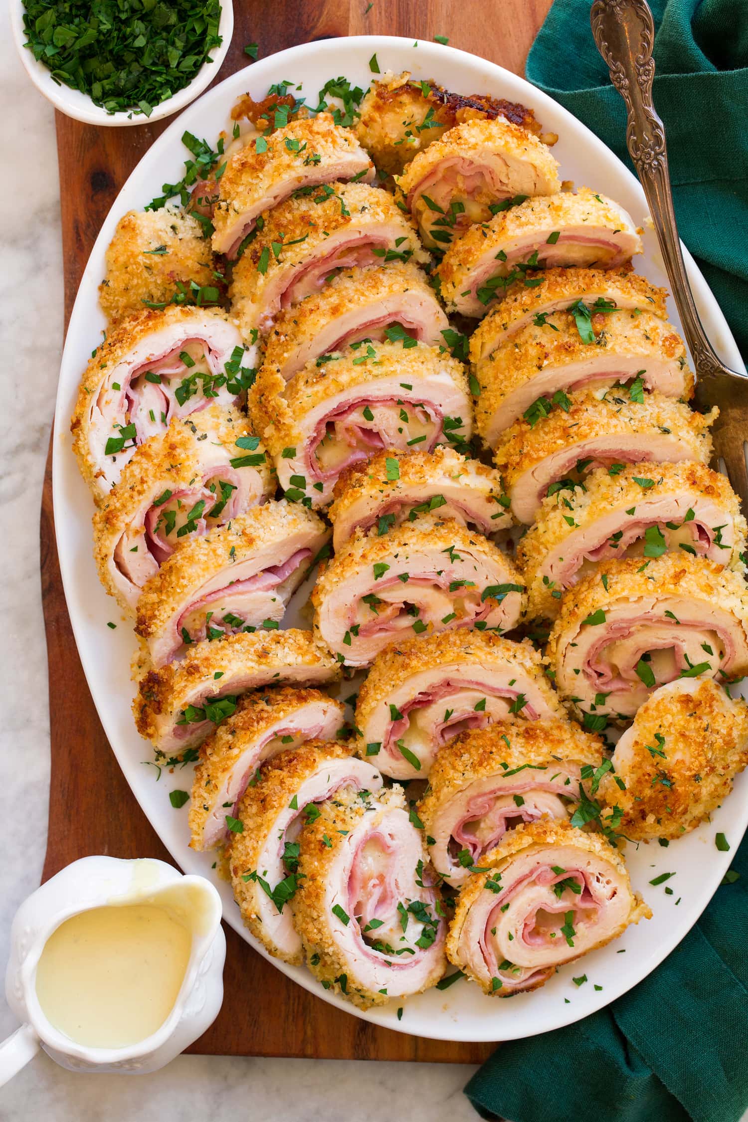 Chicken Cordon Bleu cut into slices and shown an a white oval serving tray.