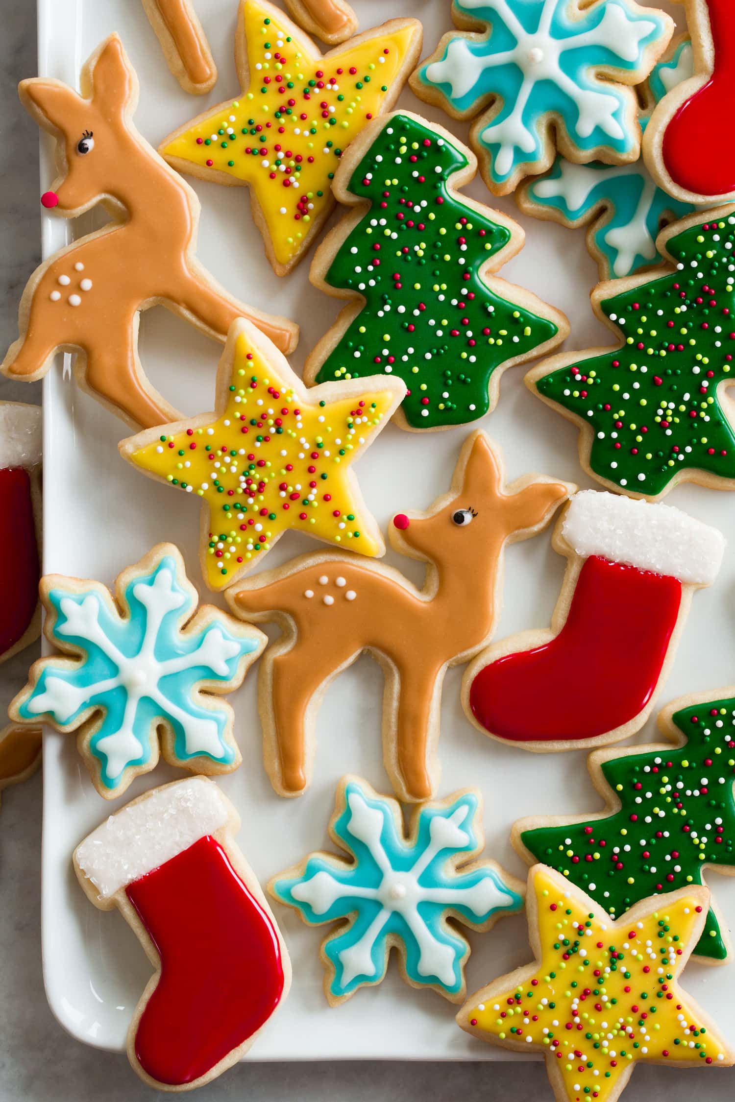 Sugar cookie icing shown over cookies in various colors and shapes.