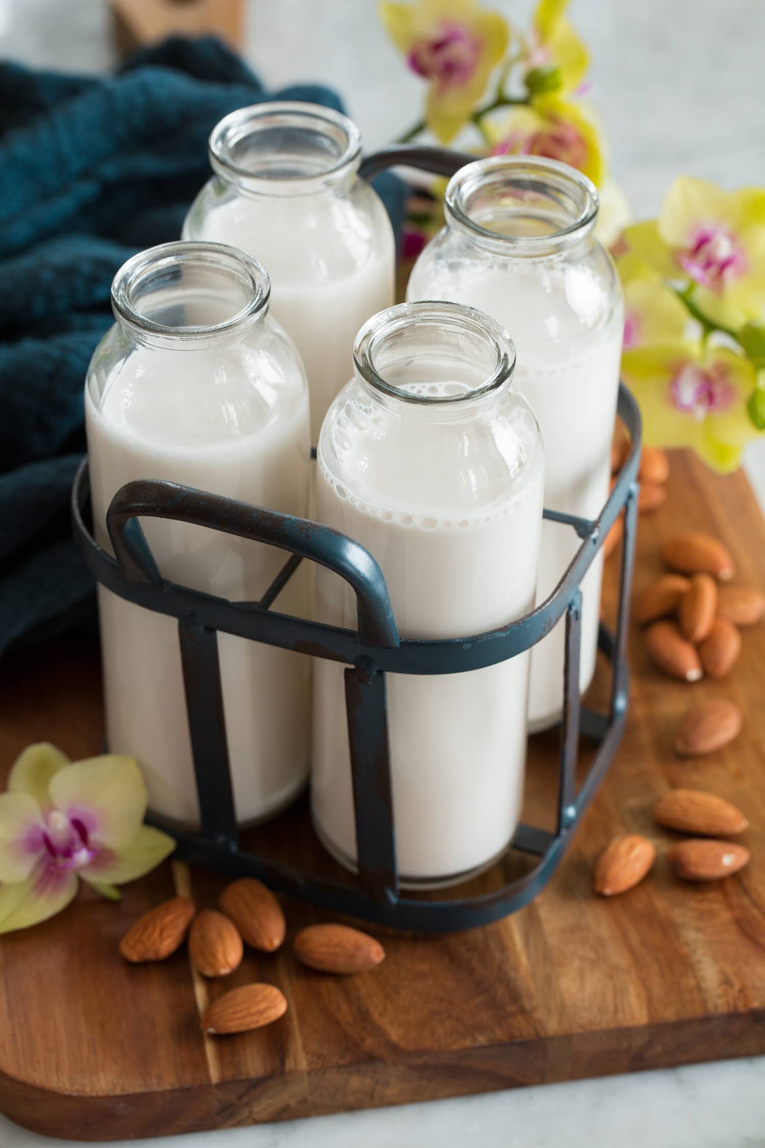 Four servings of almond milk in a vintage milk carrier.
