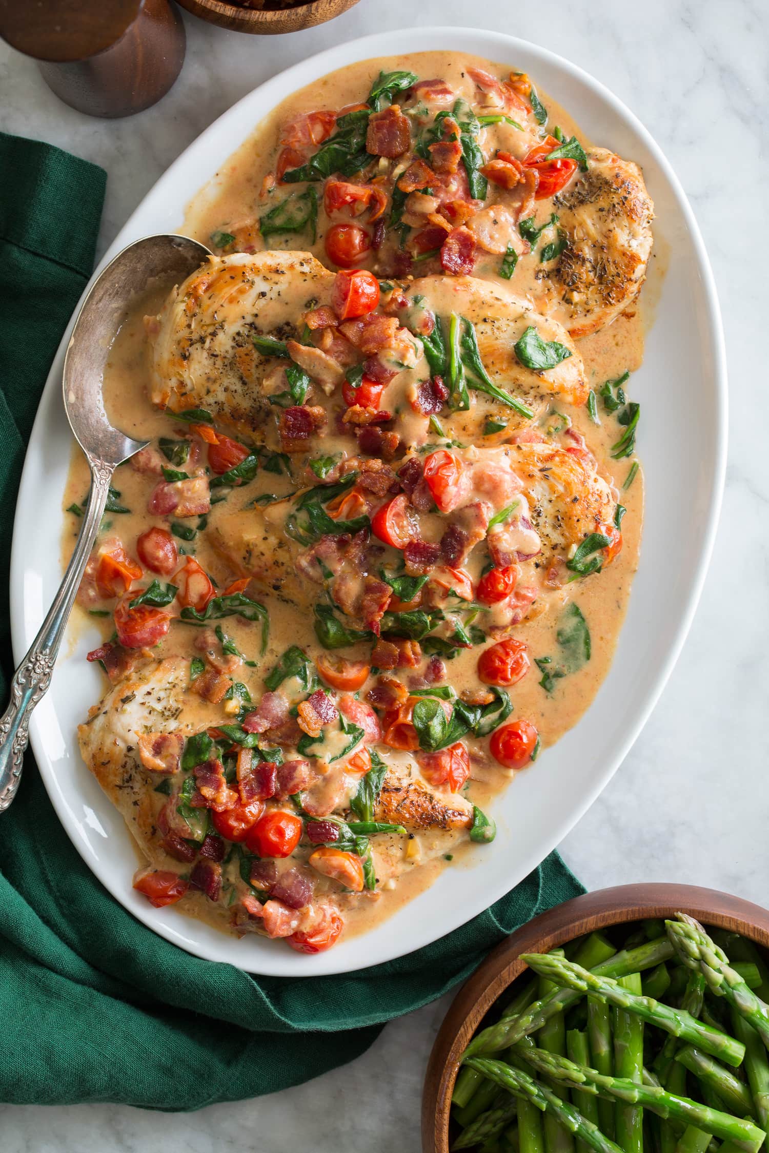 Pan seared chicken with cream bacon tomato spinach sauce.