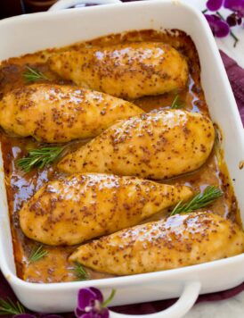 Honey mustard chicken in a baking dish lined up in a row.