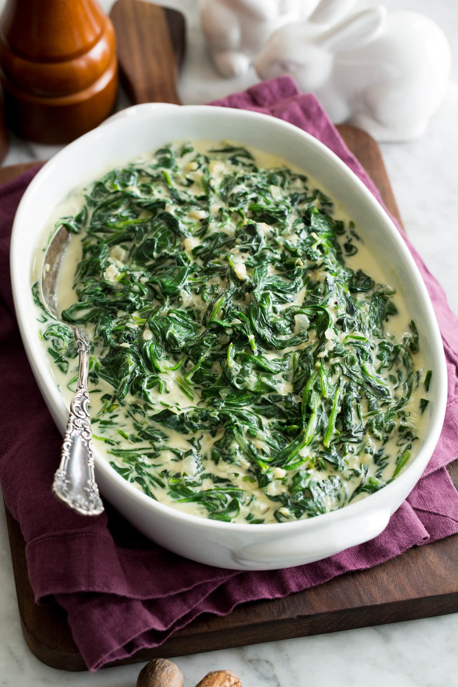 Homemade creamed spinach in a white oval serving dish.
