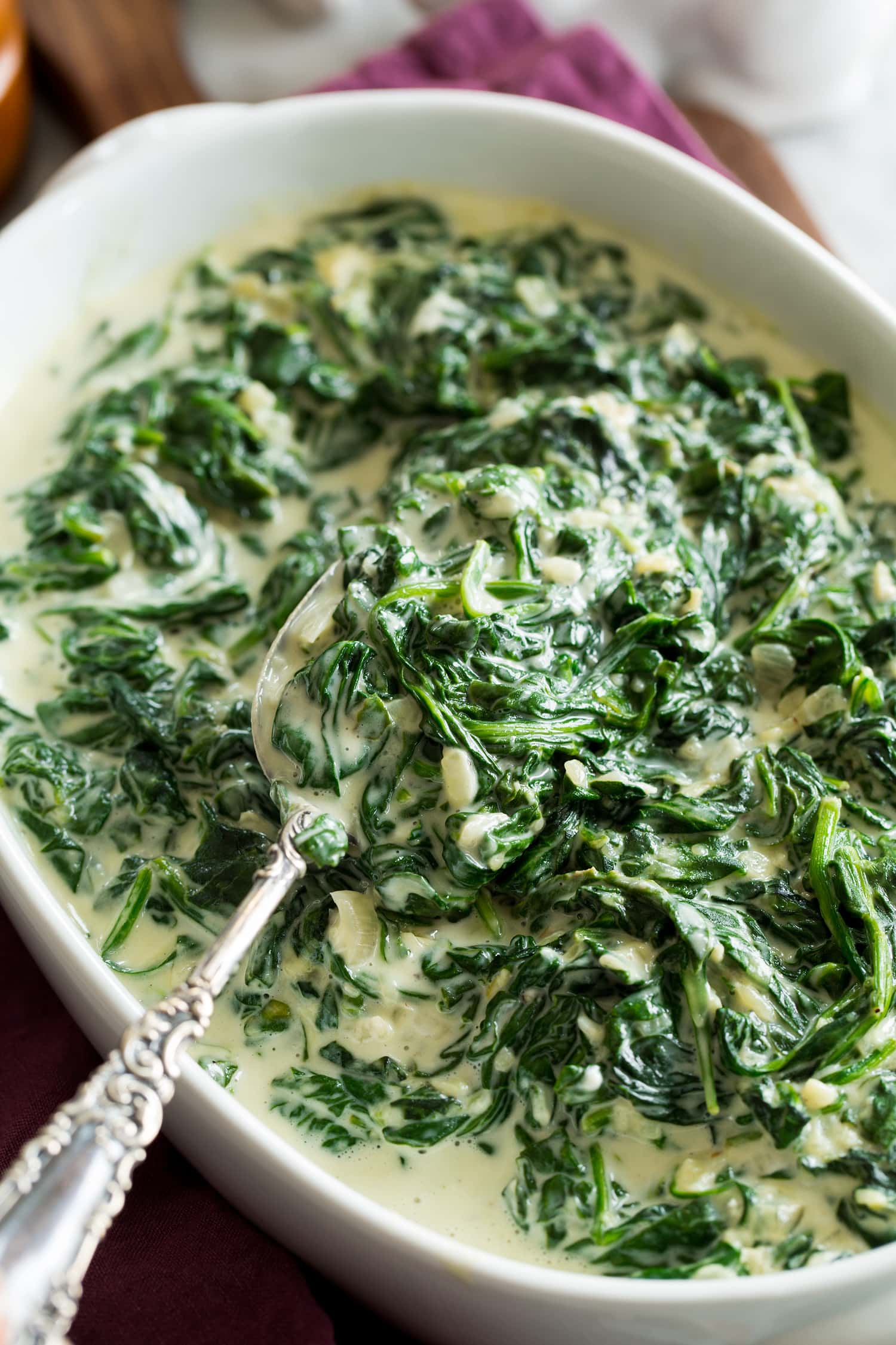Close up photo of cooked spinach with cream.