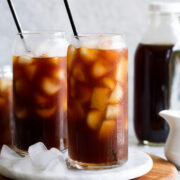 Cold brew with ice shown in glass cups with metal straws.