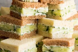 Close up photo of stack of cucumber sandwiches on a cake stand.