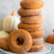 Stack of homemade baked pumpkin donuts covered in cinnamon sugar.